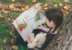 Child reading a book on essential oils for kids with her diffuser bear